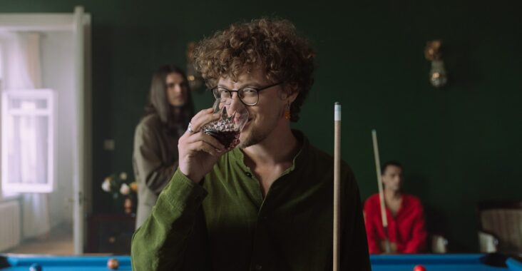 Un homme boit un verre d’alcool lors d’une partie du jeu à boire la marguerite